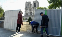 Des ouvriers installent des palissades le 13 août 2019, prÚs de Notre-Dame de Paris en vue de la décontamination des rues alentour de la cathédrale