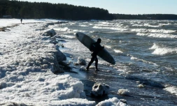 La surfeur Daniil Novozhilov, 30 ans, entre dans les eaux glacées du golfe de Finlande près du village de Lipovo près de Saint-Petersbourg le 17 février 2019