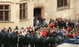 Un gréviste de la faim est sorti sur un brancard de l'église Saint-Bernard, alors qu'un groupe de sympathisants des sans-papiers est encadré par les forces de l'ordre, le 23 août 1996 à Paris
