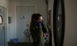 Une soigneuse du zoo "Zoom Torino" ajuste son masque de protection contre le coronavirus, le 18 mars 2020 à Cumiana, près de Turin (Italie)