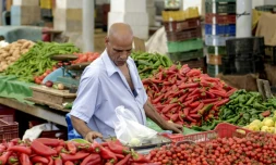 Un marchand pèse des produits sur un étal au marché populaire de Bab el-Fellah, à Tunis, le 28 juillet 2021