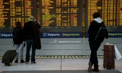 Des passagers devant le tableau des départs le 26 janvier 2016 à l'aéroport Charles-de-Gaulle à Roissy