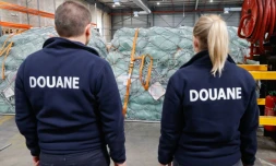 Des douaniers devant des colis de fret aérien dans un entrepôt de l'aéroport Roissy-Charles-de-Gaulle, au nord de Paris, le 29 avril 2025
