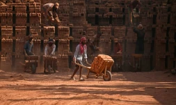 Des travailleurs migrants indiens occupés dans une briqueterie à la périphérie de Srinagar, le 24 août 2026