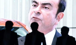 Des personnes marchent devant une photo de Carlos Ghosn, le PDG de l'alliance Renault-Nissan-Mitsubishi Motors, à Tokyo le 20 novembre 2018