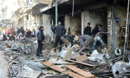 Des habitants au milieu des décombres d'immeubles après des frappes aériennes, le 4 décembre 2016 à Maaret al-Noomane, en Syrie