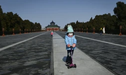 Une fillette portant un masque joue dans un parc à Pékin le 15 janvier 2020
