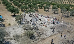Des Syriens autour des décombres d'une maison à la suite d'une frappe aérienne russe à la périphérie de la ville de Jisr al-Shughur, tenue par les rebelles, dans la province d'Idlib, le 22 juillet 2022