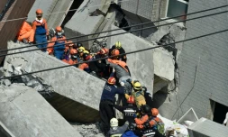 Des secouristes recherchent des survivants dans les décombres d'un immeuble le 7 février 2016, à Tainan, dans le sud de Taïwan, au lendemain d'un séisme de magnitude 6,4