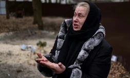 Tetiana Ustymenko weeps over the grave of her son and his two friends