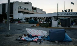 Des migrants dorment prÚs de l'aéroport international d'AthÚnes le 10 août 2016