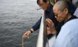 Liu Xia, veuve du Prix Nobel de la Paix Liu Xiaobo, prie alors que les cendres de son époux sont dispersées en mer, le 15 juillet 2017 au large de la ville de Dalian en Chine. Photographie fournie par le service de presse de Shenyang.