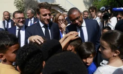 Le président Emmanuel Macron (C) et le ministre de l'Education Pap Ndiaye (D) visitent une école primaire à Marseille le 27 juin 2023