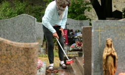 Une femme nettoie une tombe le 28 avril 2020 dans un cimetiĂšre de Reims qui vient de rouvrir