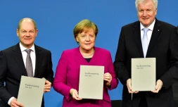 La Chancelière allemande Angela Merkel, le ministre allemand des Finances Olaf Scholz (g) et le ministre allemand de l'Intérieur Horst Seehofer, après la signature d'un accord de coalition avec les sociaux-démocrates, le 12 mars 2018 à Berlin