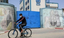Un palestinien circule en vélo devant les portes fermées d'une école gérée par l'Agence de l'ONU pour les réfugiés palestiniens (Unrwa) à Rafah, le 6 avril 2021