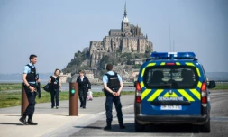 Des touristes et des gendarmes sur la route d'accÚs au Mont-Saint-Michel évacué par précaution aprÚs qu'un homme eut proféré des menaces contre les forces de l'ordre le 22 avril 2018