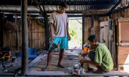 Le noble Umbu Ana Rara (g) regarde son esclave (d) Kanisius Kanyali Hambarita préparer des boissons au village de Tanggedu, dans l'est de l'île de Sumba, le 23 juin 2026 en Indonésie