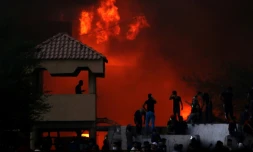 Des manifestants irakiesn devant un bâtiment officiel en feu lors de protestations le 6 septembre 2018 à Bassora, dans le sud de l'Irak