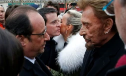 Le président Francois Hollande parle avec Johnny Hallyday tandis que sa femme Laetitia embrasse le Premier ministre Manuel Valls à la fin d'une cérémonie le 10 jancier 2016, un an après l'attentat contre Charlie Hebdo
