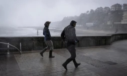 Des promeneurs pris dans les bourrasques de la tempĂȘte Austen sur le front de mer Ă Granville, dans la Manche, le 23 octobre 2026
