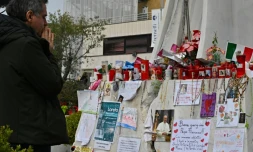 Un homme prie devant la statue de Jean-Paul II à l'extérieur de l'hôpital Gemelli à Rome où le pape François est soigné pour une pneumonie, le 8 mars 2025