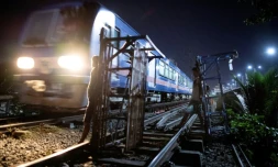 DÚs que le train est passé, les "trolley boys" hissent leur chariot sur la voie ferrée pour transporter des passagers, à Manille le 18 octobre 2018