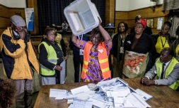 Un agent électoral renverse une urne lors des opérations de dépouillement des bulletins de vote pour les élections générales au Zimbabwe, le 30 juillet 2018 à Harare.
