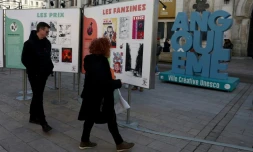 Des visiteurs regardent des affiches dans le cadre d'une exposition lors du 52e Festival international de la bande dessinée d'Angoulême, le 30 janvier 2025