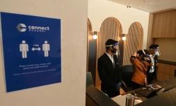 Le personnel est debout derriÚre la réception du Connect@Changi, présenté comme le premier hÎtel et centre de conférences sécurisé contre le Covid-19, le 18 février 2021 à Singapour