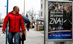 Un Croate regarde une affiche de la présidente Kolinda Grabar-Kitarovic, candidate à sa propre réelection, le 21 décembre 2019 à Zagreb