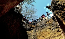 Des mineurs illégaux au bord d'un trou dans lequel ils espèrent trouver des rubis, près de Montepuez, le 3 août 2018 au Mozambique