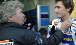 L'ancien champion du monde espagnol de moto Angel Nieto (g) félicite son fils Pablo, 2e sur la grille de départ des 125 cc au GP de la Communauté de Valence, le 1er novembre 2003 à Cheste en Espagne