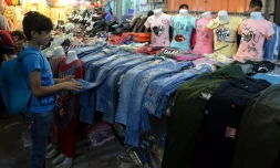 Un garçon irakien regarde des jeans sur un marché le 14 juin 2018. A Mossoul, pour l'Aïd el-Fitr, les petits Irakiens recevront des jouets en pagaille mais pas de pistolets et autres armes en plastique, pour tourner la page des jihadistes du groupe Etat islamique (EI)
