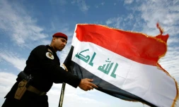 Un policier irakien devant le drapeau de l'Irak, à Najaf le 9 janvier 2016