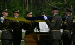 Des militaires de la garde d’honneur ukrainienne tiennent des drapeaux nationaux au-dessus des cercueils contenant les dépouilles d’Andriy Melnyk, mort en 1964 et chef d’une branche de l’Organisation des nationalistes ukrainiens (OUN) lors de leur cérémonie de réinhumation au cimetière militaire national près de Kiev, le 25 mai 2026