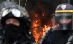 Des CRS devant un incendie en marge de la manifestation du 1er Mai Ă Paris