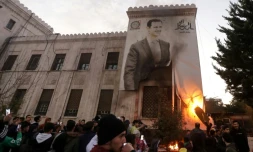 Des résidents mettent le feu à un portrait géant du président syrien à Hama, après la prise de la ville par les rebelles, le 5 décembre 2024