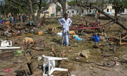Le 11 décembre 2016 un homme se trouve au milieu d'objets épars sur les lieux de l'attentat-suicide au camion piégé près de l'entrée du port de Mogadiscio et qui a fait plus de 20 morts