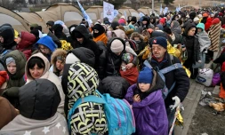 Des rĂ©fugiĂ©s font la queue dans le froid en attendant d'ĂȘtre transfĂ©rĂ©s dans une gare aprĂšs avoir traversĂ© la frontiĂšre ukrainienne vers la Pologne, au poste frontiĂšre de Medyka en Pologne, le 7 mars 2022
