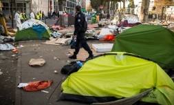 Un policier marche au milieu de tentes de migrants près du Quai de Jemmapes (nord de Paris), le 31 octobre 2016