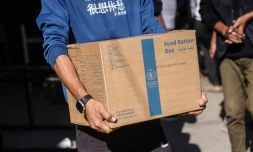 Un Palestinien porte un colis alimentaire fourni par le Programme alimentaire mondial le 27 octobre 2025 dans le centre de la bande de Gaza