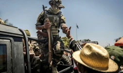 Un militaire malgache salue du poing un civil alors que des manifestants se rassemblent pour un meeting de la société civile devant l'hôtel de ville d'Antananarivo, le 13 octobre 2025