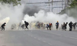 Des manifestants anti-coup d'Etat en Birmanie fuient les gaz lacrymogènes tirés par les forces de l'ordre, à Mandalay le 15 mars 2021