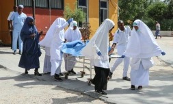 Des religieuses emmènent pour des soins une personne blessée lors de l'explosion d'une voiture piégée le 8 janvier 2019 à Mogadiscio