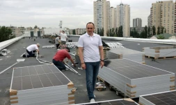 NazariĂŻ Guitchka, directeur de la maternitĂ© de Kiev, sur le toit de l'Ă©tablissement oĂč des ouvriers installent des panneaux solaires, le 14 juin 2024 en Ukraine
