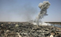 Une colonne de fumée se dégage de la ville irakienne de Mossoul après un raid de la coalition internationale dirigée par les Etats-Unis, en soutien aux forces irakiennes au sol face aux jihadistes, le 9 juillet 2017 