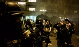 Un manifestant utilise du sérum physiologique pour atténuer les effets des gaz lacrymogÚnes alors qu'il fait face à la police anti-émeute lors d'une manifestation à Lyon, dans l'est de la France, le 20 mars 2023 ( AFP / JEFF PACHOUD )
