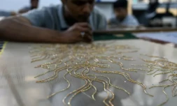Des brodeurs de l'atelier Shanagar travaillent sur une piÚce de tissu pour le couturier français Julien Fournié, le 7 janvier 2023 à Bombay, en Inde ( AFP / Punit PARANJPE )