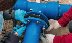 Workers installing water supply pipeline system, close up.